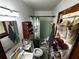 Cozy bathroom featuring a sink, toilet, shower with curtain, and shoe storage at 2933 Arlington Rd, East Point, GA 30344