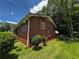 Exterior shot of the brick home showing the side and fenced yard, with mature landscaping at 2933 Arlington Rd, East Point, GA 30344