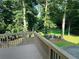 View from a deck overlooking a backyard with mature trees, and a seating area at 3201 Palisades Se Ct, Marietta, GA 30067