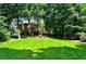 Beautiful backyard view with a large lawn and mature trees surrounding the home at 3201 Palisades Se Ct, Marietta, GA 30067