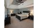 Spacious bedroom with a tray ceiling, ceiling fan, and stylish, dark-wood furniture at 3201 Palisades Se Ct, Marietta, GA 30067