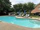 Community pool surrounded by lounge chairs, lush landscaping, and shade trees at 3201 Palisades Se Ct, Marietta, GA 30067