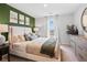 Stylish main bedroom with decorative green accent wall, large window and modern furniture creating a relaxing retreat at 508 Crown Dr, Emerson, GA 30137