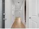 Well-lit hallway with hardwood floors leading to a staircase with neutral carpeting at 512 Crown Dr, Emerson, GA 30137