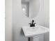 Elegant bathroom with a pedestal sink and a circular mirror, highlighting the room's simple design at 514 Crown Dr, Emerson, GA 30137