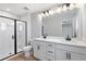 This bathroom features a double vanity with black fixtures, a large mirror, and a walk-in shower with a black frame at 514 Crown Dr, Emerson, GA 30137