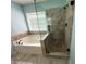 Bathroom featuring garden tub and glass enclosed shower with decorative tile at 8130 Estee Dr, Cumming, GA 30028