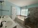 Bathroom featuring double sink vanity, garden tub, and glass enclosed shower at 8130 Estee Dr, Cumming, GA 30028