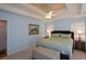 Bedroom featuring tray ceiling, large bed, and bedside tables at 8130 Estee Dr, Cumming, GA 30028