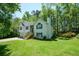 Two-story home with a well-maintained lawn, lush greenery, and a partial view of the deck at 8130 Estee Dr, Cumming, GA 30028