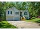 Charming two-story home with attached garage, stone accents, and landscaped front yard surrounded by mature trees at 8130 Estee Dr, Cumming, GA 30028