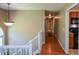 Hallway with hardwood floors, neutral walls, overhead lighting, and a staircase, leading to the kitchen at 8130 Estee Dr, Cumming, GA 30028