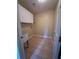 Laundry room features white cabinets, wash sink, wall shelving, and tile flooring at 8130 Estee Dr, Cumming, GA 30028