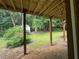 View from covered patio into backyard featuring mature trees and an outbuilding at 8130 Estee Dr, Cumming, GA 30028