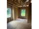 Unfinished bedroom features two windows with view of wooded backyard, and exposed framing ready for drywall at 1163 Park Center Cir, Austell, GA 30168