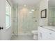 Modern bathroom featuring marble tile shower with glass door and white vanity, exuding cleanliness and sophistication at 1272 Hardee Ne St, Atlanta, GA 30307