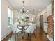 Bright eat-in kitchen with stainless steel appliances, white cabinetry, and a modern lighting fixture at 1272 Hardee Ne St, Atlanta, GA 30307