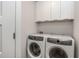 This laundry area features a washer and dryer with cabinets above and a door on the side at 1272 Hardee Ne St, Atlanta, GA 30307