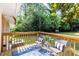 Wooden back deck with outdoor seating, decor, lighting, and view of the backyard and mature trees at 3205 Mcafee Rd, Decatur, GA 30032