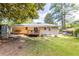 Spacious backyard with a wooden deck, mature trees, well-maintained lawn, and the back of the house at 3205 Mcafee Rd, Decatur, GA 30032