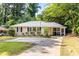 Charming single-story home with a well-manicured lawn, screened in porch and a concrete driveway at 3205 Mcafee Rd, Decatur, GA 30032