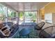 Relaxing screened porch featuring comfortable seating, patterned rug, brick wall, and view of the front yard at 3205 Mcafee Rd, Decatur, GA 30032