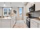 Bright kitchen features white cabinetry, stainless appliances, an island, and wood-look floors at 510 Crown Dr, Emerson, GA 30137
