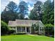 Charming home featuring a quaint front porch and beautifully manicured lawn, nestled among mature trees at 60 Stonehedge Dr, Buford, GA 30518