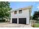 Shot of the side of the house, featuring white painted brick and black garage doors at 1894 Twin Falls Rd, Decatur, GA 30032