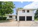 Two-story home features white painted brick, black windows, two car garage, and mature landscaping at 1894 Twin Falls Rd, Decatur, GA 30032