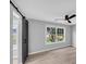 Bedroom with a sliding barn door, ceiling fan, and natural light at 5195 Oaks Landing Ct, Sugar Hill, GA 30518