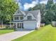 Charming two-story home featuring a manicured lawn and a two-car garage at 5195 Oaks Landing Ct, Sugar Hill, GA 30518