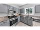 Well-equipped kitchen with stainless steel appliances, gray cabinets, and granite countertops at 5195 Oaks Landing Ct, Sugar Hill, GA 30518