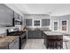 Modern kitchen with gray cabinets, stainless steel appliances, and stone countertops with eat in island at 5195 Oaks Landing Ct, Sugar Hill, GA 30518