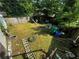 View of a fenced-in backyard with a tire, ladder and trash cans at 6733 Old Covington Rd, Lithonia, GA 30058