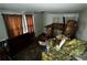 Bedroom view showing damaged ceiling and floor needing renovation, plus outdated curtains on bright windows at 6733 Old Covington Rd, Lithonia, GA 30058