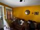 Living room with armchairs, yellow walls, and minimal natural light at 6733 Old Covington Rd, Lithonia, GA 30058