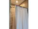 Close-up of a shower with neutral tile, a shower curtain, and modern fixtures at 842 Shoals Ct, Atlanta, GA 30349