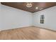 Spacious bedroom featuring hardwood floors, wooden slat ceiling, modern ceiling fan and a large window at 1337 Fairfield Dr, Lilburn, GA 30047