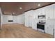 Open-concept living room with hardwood floors, fireplace, and modern light fixtures at 1337 Fairfield Dr, Lilburn, GA 30047