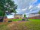 A green backyard with patio seating, a two-story home, and a fire pit at 171 Shaker Hollow Drive Dr, Mcdonough, GA 30253