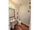 Charming half bathroom featuring wood floors, pedestal sink, and decorative accents at 171 Shaker Hollow Drive Dr, Mcdonough, GA 30253