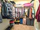 Organized walk-in closet with hanging clothes, folded items, and storage containers on shelves and the floor at 171 Shaker Hollow Drive Dr, Mcdonough, GA 30253