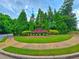 Landscaped community entrance sign with lush greenery and flowers at 171 Shaker Hollow Drive Dr, Mcdonough, GA 30253