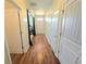 Well-lit hallway featuring wood flooring and several doors leading to various rooms at 171 Shaker Hollow Drive Dr, Mcdonough, GA 30253