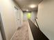 Upstairs hallway with neutral carpet, white walls, white doors, and dark railing overlooking the stairs at 171 Shaker Hollow Drive Dr, Mcdonough, GA 30253