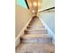 Carpeted staircase with a sturdy handrail and white trim, leading to the upper level of the home at 171 Shaker Hollow Drive Dr, Mcdonough, GA 30253