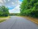 Street view showing a street lined with trees and a building in the background on a cloudy day at 171 Shaker Hollow Drive Dr, Mcdonough, GA 30253