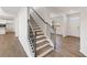 Stylish staircase with wood steps, dark railings, and bright white walls leading to a kitchen area at 237 Arwen Drive Lot 61, Mcdonough, GA 30252
