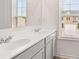 Bright bathroom features dual sinks, white countertops, and a large mirror at 235 Silver Moon Dr, Loganville, GA 30052